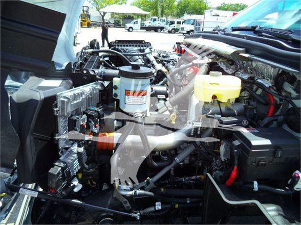 Truck engine bay showing Silverado 6500HD with exposed components and hoses.