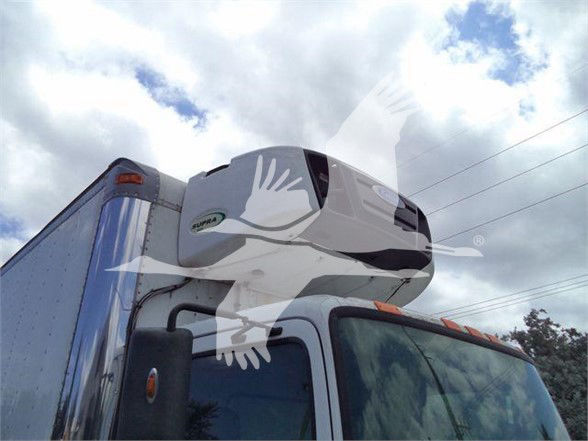 Truck cab with a mounted reefer unit on top of the sleeper. Visible windshield and side window.