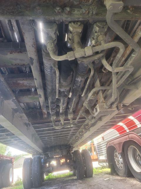 Underbody view of a used Warren WHDT48x102-2-AS walking floor trailer showing multiple hydraulic lines and frame components.