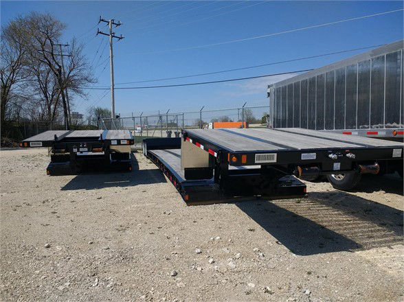 Fontaine 40-ton mechanical detachable double drop trailer in an outdoor lot, showings flatbed with tandem axles and reflective safety markings.