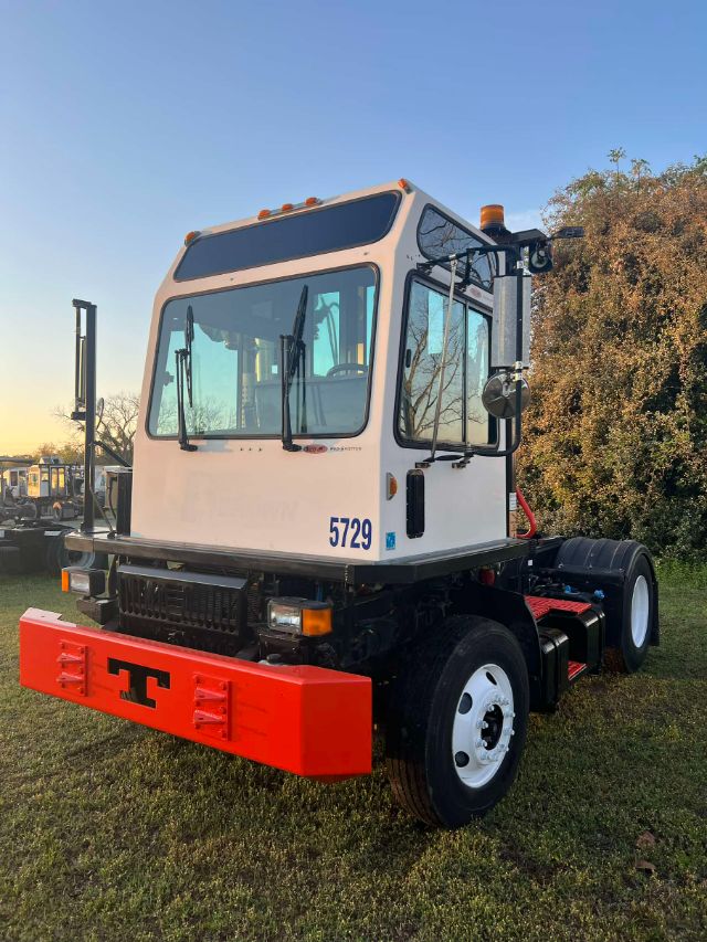 Truck cab of a 2014 Tico PROSPOTTER yard truck with white cab, black windows, orange beacon lights, and a bright red front bumper with black T letters.