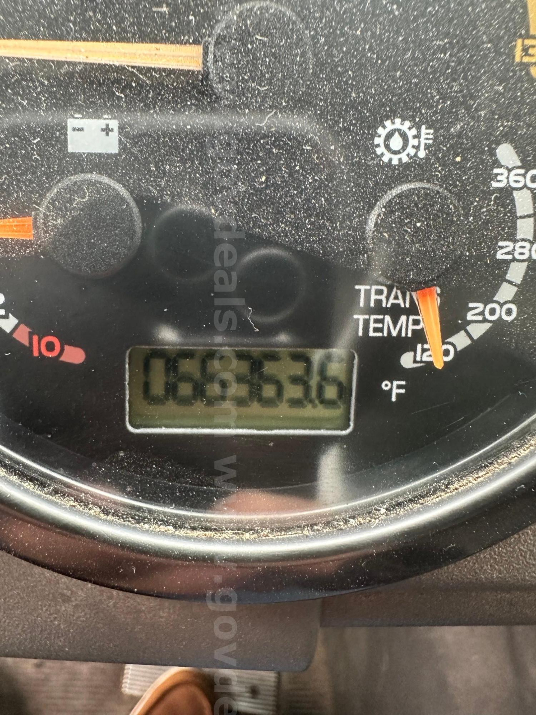 Dashboard gauge cluster showing temperature and speedometer with digital odometer reading 006,536 miles on a Mack MRU613 truck.