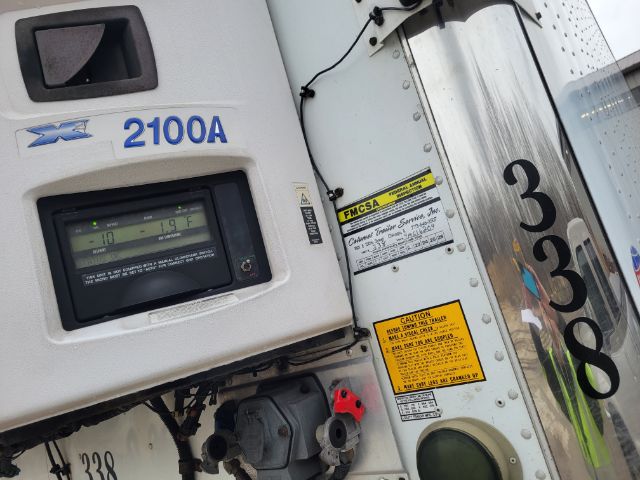 Rear of a refrigerated trailer with a Rex-X 2100A unit, digital display, and yellow safety labels; visible numbers 338 and 5338 on nose and door frame.