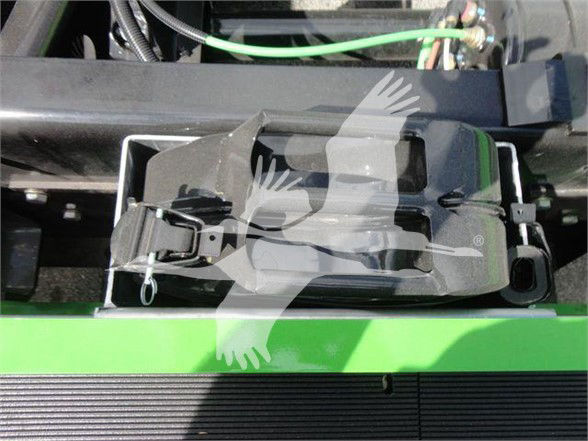 Interior hardware and latch components in a truck bed area of a 2024 International MV tow truck showing hydraulic latches and wiring harnesses.