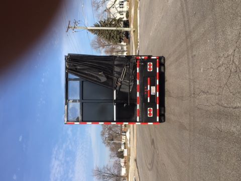Rear view of a 2002 Great Dane single drop trailer with a black tarp partially covering an opening, red and white reflective tape along the edges, and rear lights visible.