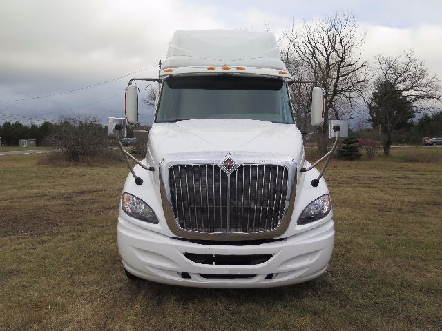 International ProStar front view showing large vertical grille, projector headlights, white cab with aerodynamic mirrors.
