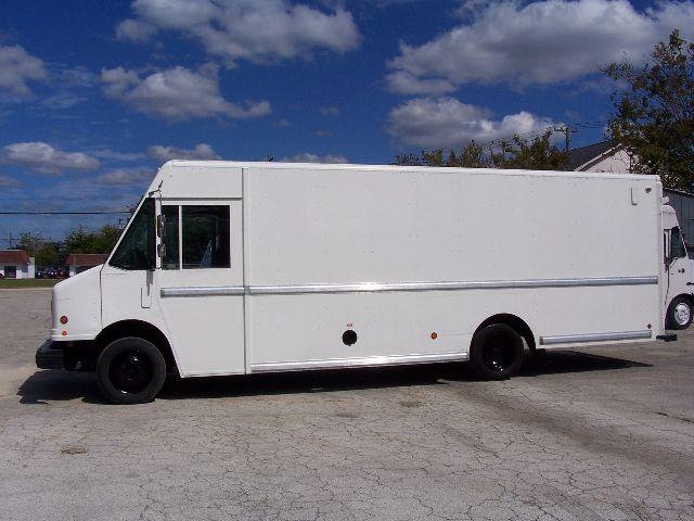 White box truck/van with high roof, side panels, no visible branding, black wheels, and clear sky.
