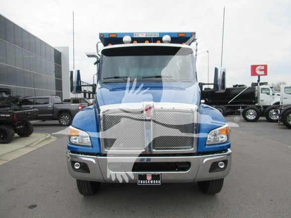 Kenworth T380 dump truck front view showing blue cab with chrome grille and bumper; visible headlights, mirrors, and front license plate area.