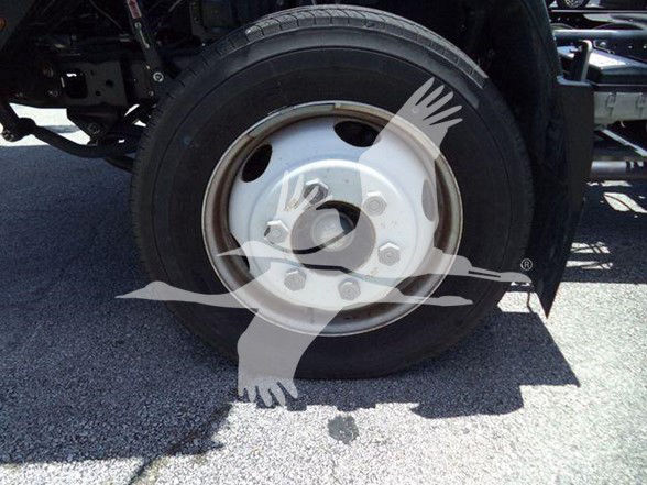 Isuzu truck wheel/tire and rim visible in a dump truck undercarriage.