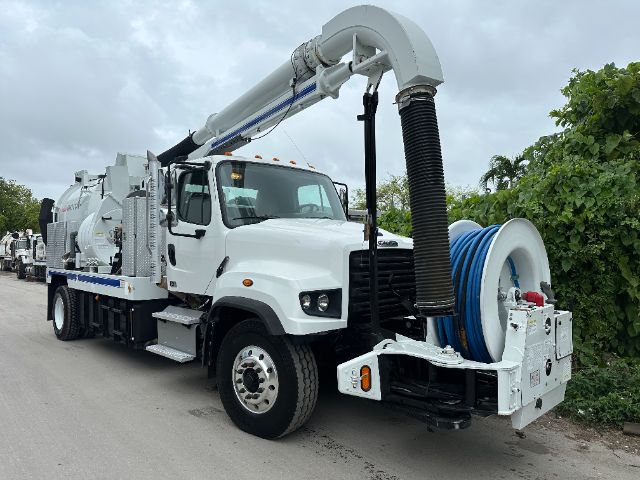 Front view of a white 2014 Freightliner 114SD vacuum truck with large hose reel and vacuum arch equipment.