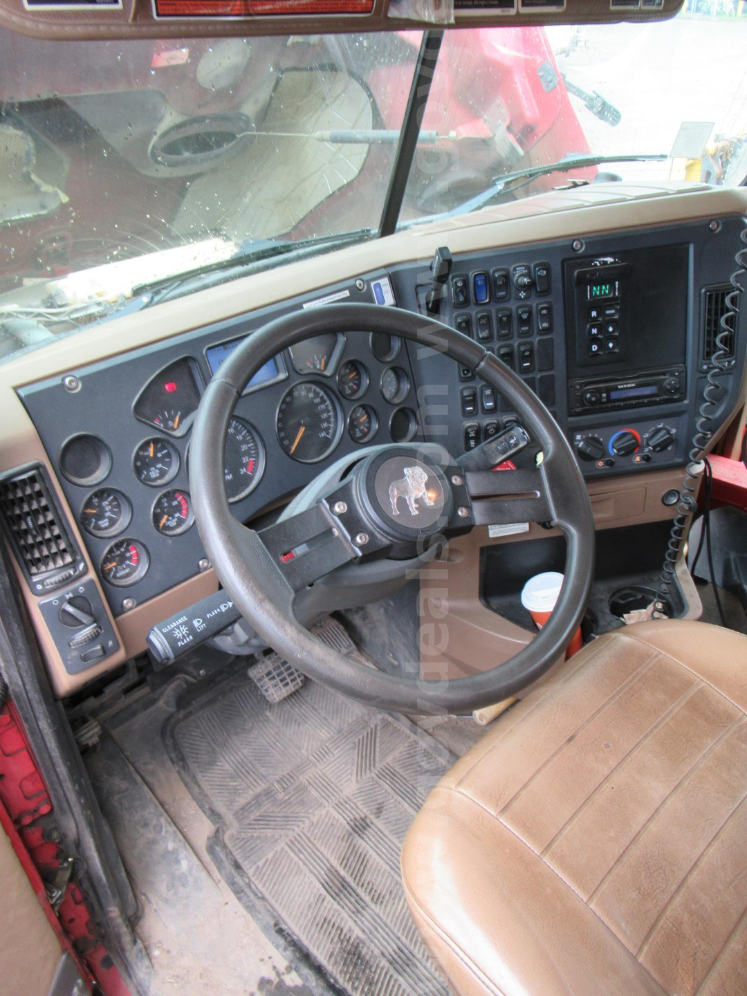 Truck cab interior of a 2014 Mack GU713 showing steering wheel, dashboard gauges, control panels, and center stack.