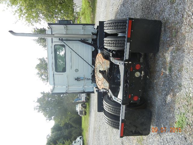 Truck cab and chassis with flatbed/tilt bed, Volvo VNL series, rear view showing dual rear tires, hitch, and rear lights. Visible date stamp 09 07 2015.