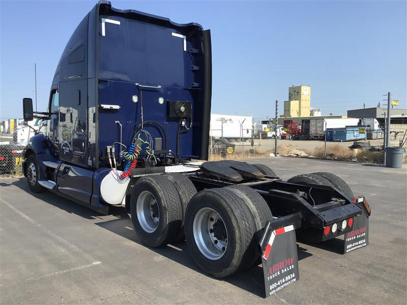 Kenworth T680 rear view showing fifth wheel and dual rear axles with fuel lines and air hoses.