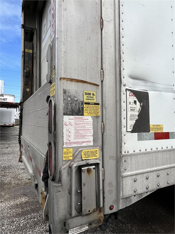 Trailer rear corner showing label stickers on a 2015 Great Dane dry van, with yellow capacity sticker and ignition of rear corner hardware.