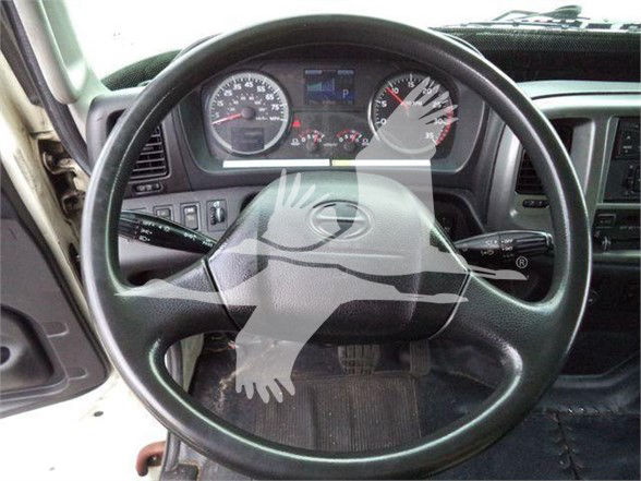 Truck cab interior showing steering wheel and instrument cluster with gauges visible.