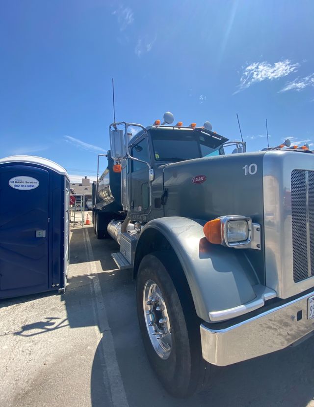 Peterbilt 365 dump truck side-front view with chrome bumper and multiple marker lights showing 10 on fender and large grille.