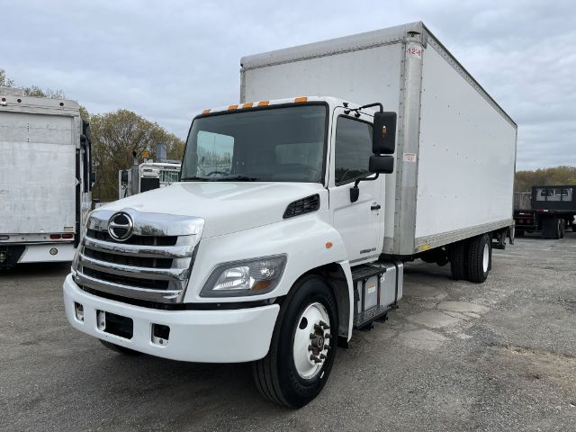 Box truck showing a white 2017 Hino 268 with a large box cargo area, cab mirrors, and front grille; CDL trucking vehicle in a lot.
