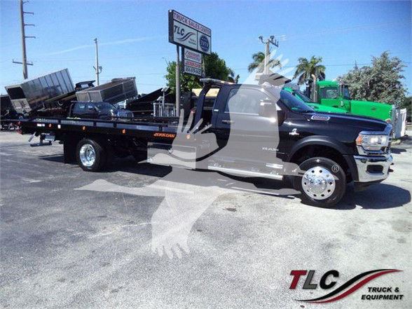 Ram 5500 tow truck with flatbed, side view showing front grille, cab, and flatbed.