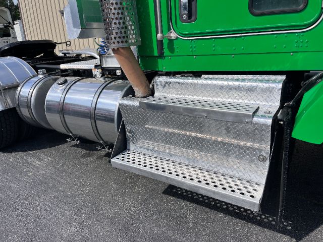 Kenworth T800 side view showing polished aluminum fuel tanks and diamond plate side steps.