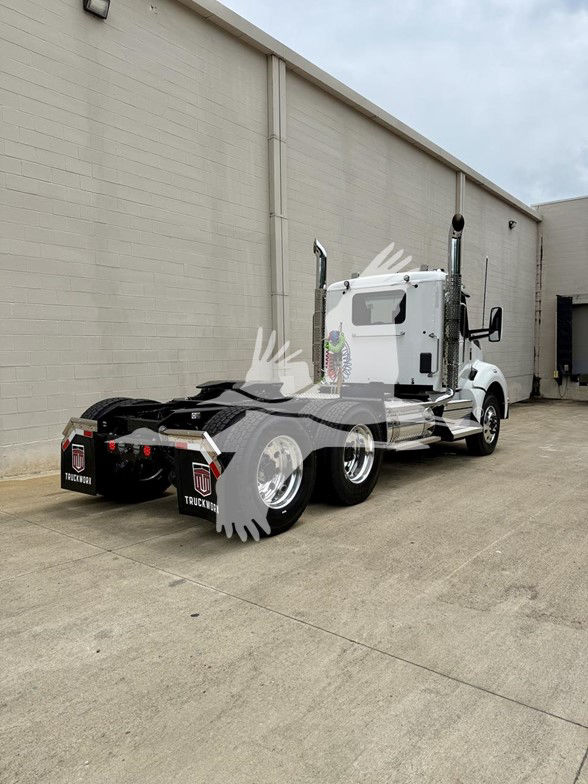 Kenworth T880 truck rear-side view with dual rear axles and white cab, chrome exhaust stacks, and black fifth-wheel area.