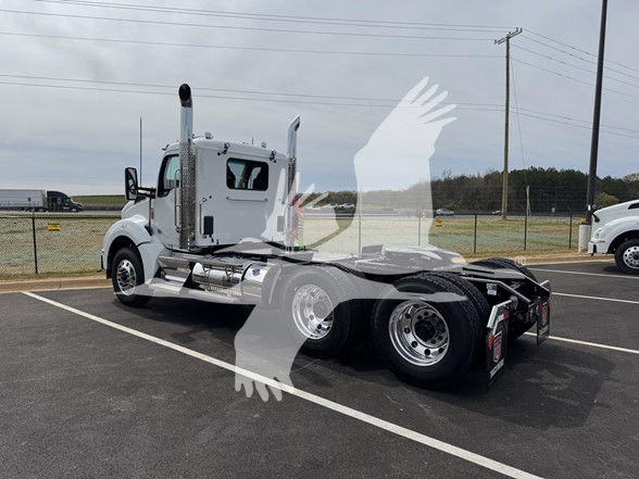 Kenworth T880 cab and chassis truck in a dealership lot with faint watermark overlay showing rear wheel area and fifth wheel.