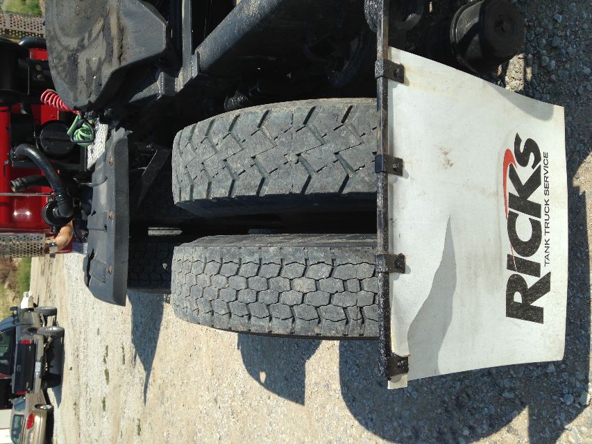 Kenworth T800 rear dual rear tires with mud flap displaying Rick's Tank Truck Service logo.