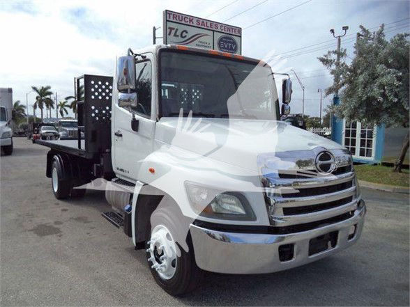 2017 Hino 258LP hooklift truck with white cab, chrome bumper, and black hooklift body. VIN 5PVNJ8JNXH4S52712 visible on listing, stock T52712.