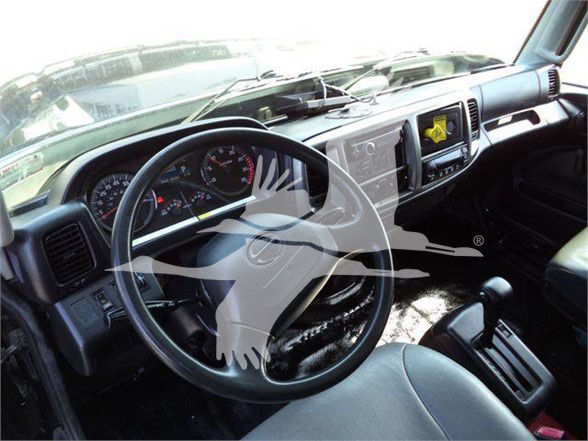 Truck cabin interior showing steering wheel, dashboard gauges, and center console.