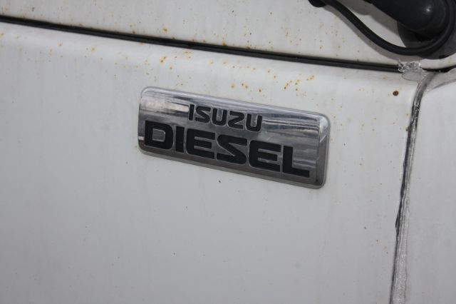 Isuzu NPR-HD door badge reading ISUZU DIESEL on white truck panel.
