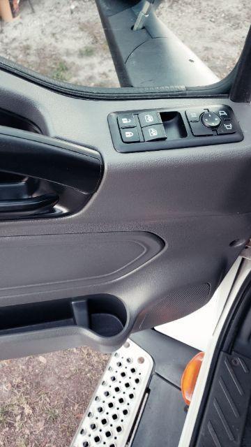 Truck cab interior window control panel and door with palm rest and speaker grille visible.