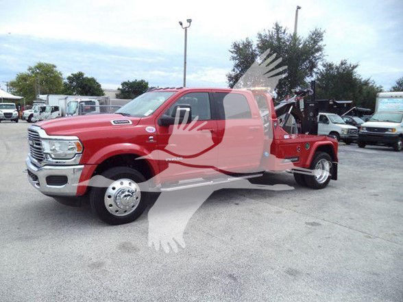 2024 Ram 5500 Laramie tow truck with red body and black accents; side view showing front grille and dual rear wheels.