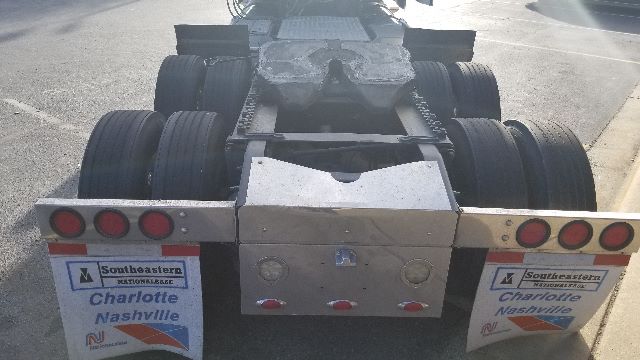 Rear view of a 2013 Freightliner Coronado 132 tractor chassis showing dual rear axles and mud flaps with Southeastern truck decals.