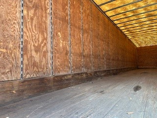 Interior of a Great Dane dry van trailer with plywood walls and wooden ceiling framing.