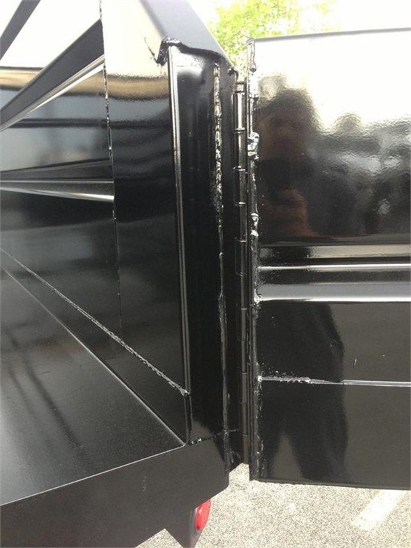 Dump Body side corner showing hinge area and panel joints on a black truck bed.
