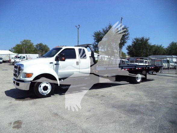 2015 Ford F650 XLT tow truck with flatbed in a dealership lot.
