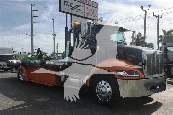 2022 Peterbilt 337 tow truck front-right view with painted graphic art on cab and chrome bumper.