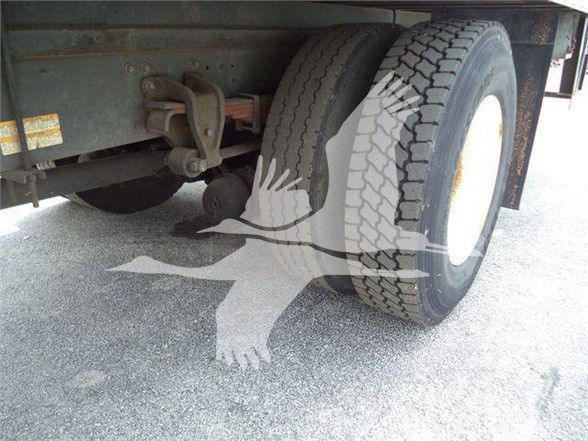 Rear-left wheel and suspension of a reefer truck showing dual tires and undercarriage components.