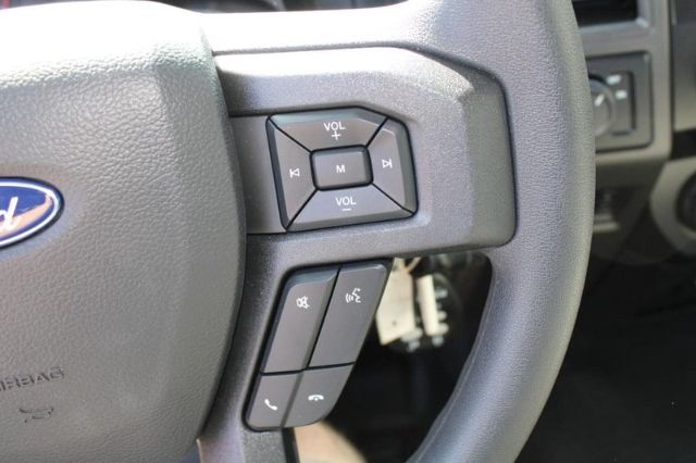 Ford steering wheel controls in a 2022 F-250 showing volume controls, media mute, and phone buttons on the left spoke.