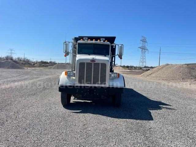 Peterbilt dump truck front view showing large grille, headlights, and side mirrors.