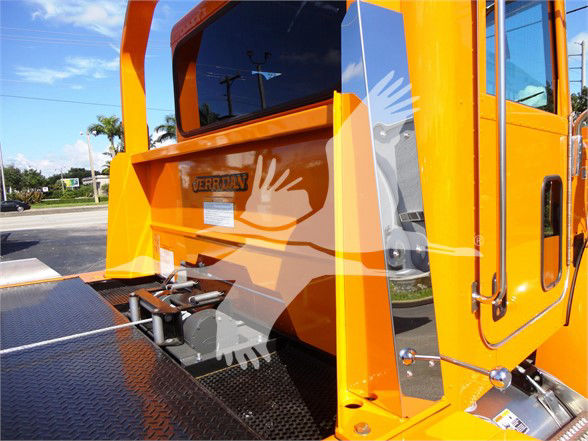 Tow truck rear with bright orange cab and diamond plate platform, Peterbilt logo visible on tail, side door and rear deck handles.