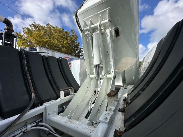 Freightliner 114SD truck component showing hydraulic lift mechanism and metal frame in a vacuum body.