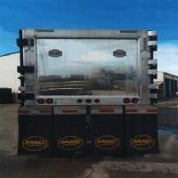 Dump trailer rear view showing steel frame and three axles with black wheels, chrome bumper hardware, and reflective markers.