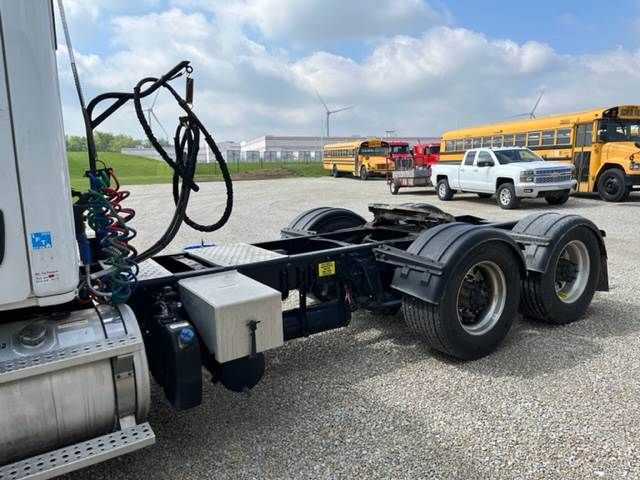 Chassis of a 2015 Freightliner Cascadia truck showing rear wheel assembly, exposed air lines, and cab attachment area.