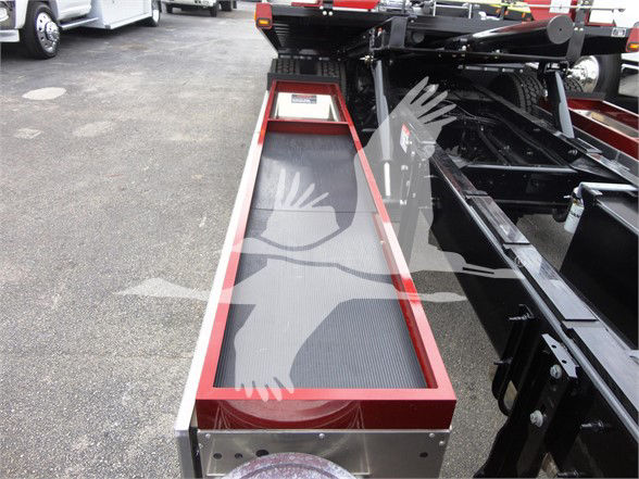Tow truck chassis with a long rectangular step or loading belt in red framing, showing metal frame and black rubber surface.