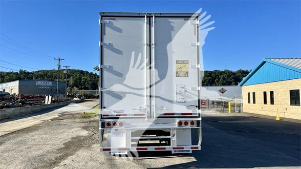 Rear view of a Vanguard Cool Globe trailer with double doors, reflective rear bumper, and warning labels on the right door.