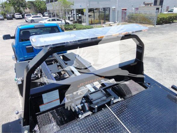 Ram 5500 tow truck bed with hydraulic winch and control panel. Visible labels on metal plate and sticker near base.