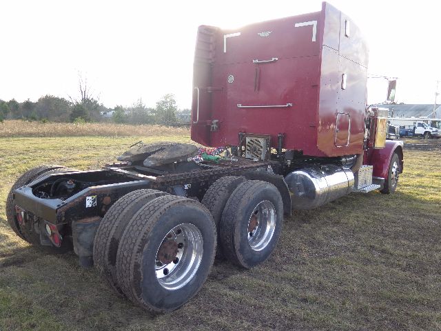 Peterbilt 388 conventional sleeper tractor with red cab, dual rear axles, and chrome fuel tanks.