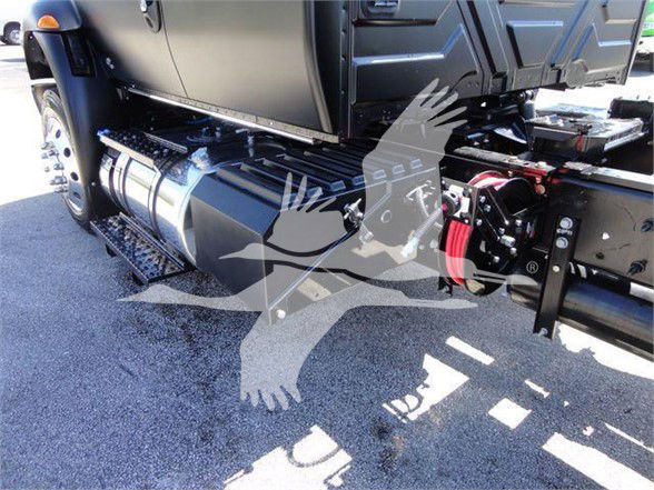 Truck undercarriage showing large fuel tank, side steps, and PTO/hoses with red hydraulic components; partial logo overlay