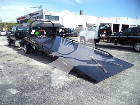 Tow truck flatbed trailer with ramps extended in a dealership lot, 2023 International CV, VIN 1HTKTSWK3PH419804, stock J19804.