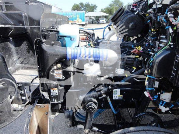 Peterbilt 337 engine bay showing visible belts, wiring harness, coolant reservoir, and various engine components.